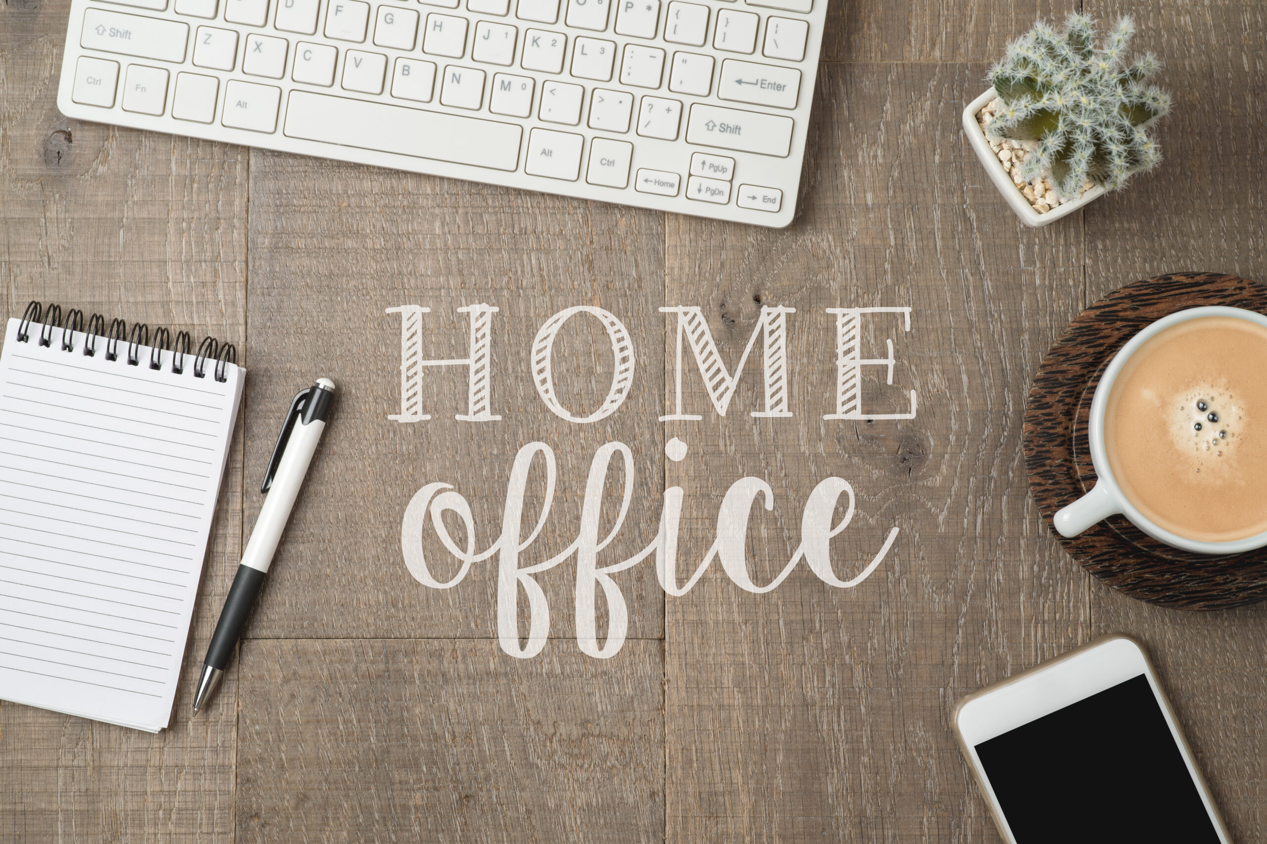 Home office and working from home concept. Table workplace with keyboard computer, notepad and coffee cup. Top view from above Home office and working from home concept. Table workplace with keyboard computer, notepad and coffee cup. Top view from above