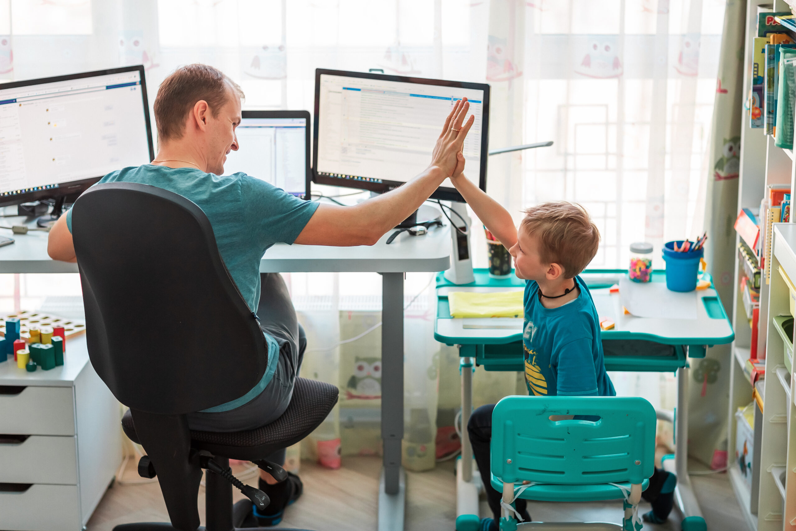 Father with kid working from home during quarantine. Stay at home, work from home concept during coronavirus pandemic Father with kid trying to work from home during quarantine. Stay at home, work from home concept during coronavirus pandemic