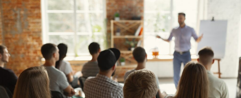 Person hält einen Vortrag vor kleinem Publikum über Personal Branding.