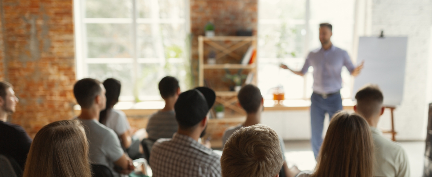 Person hält einen Vortrag vor kleinem Publikum über Personal Branding.
