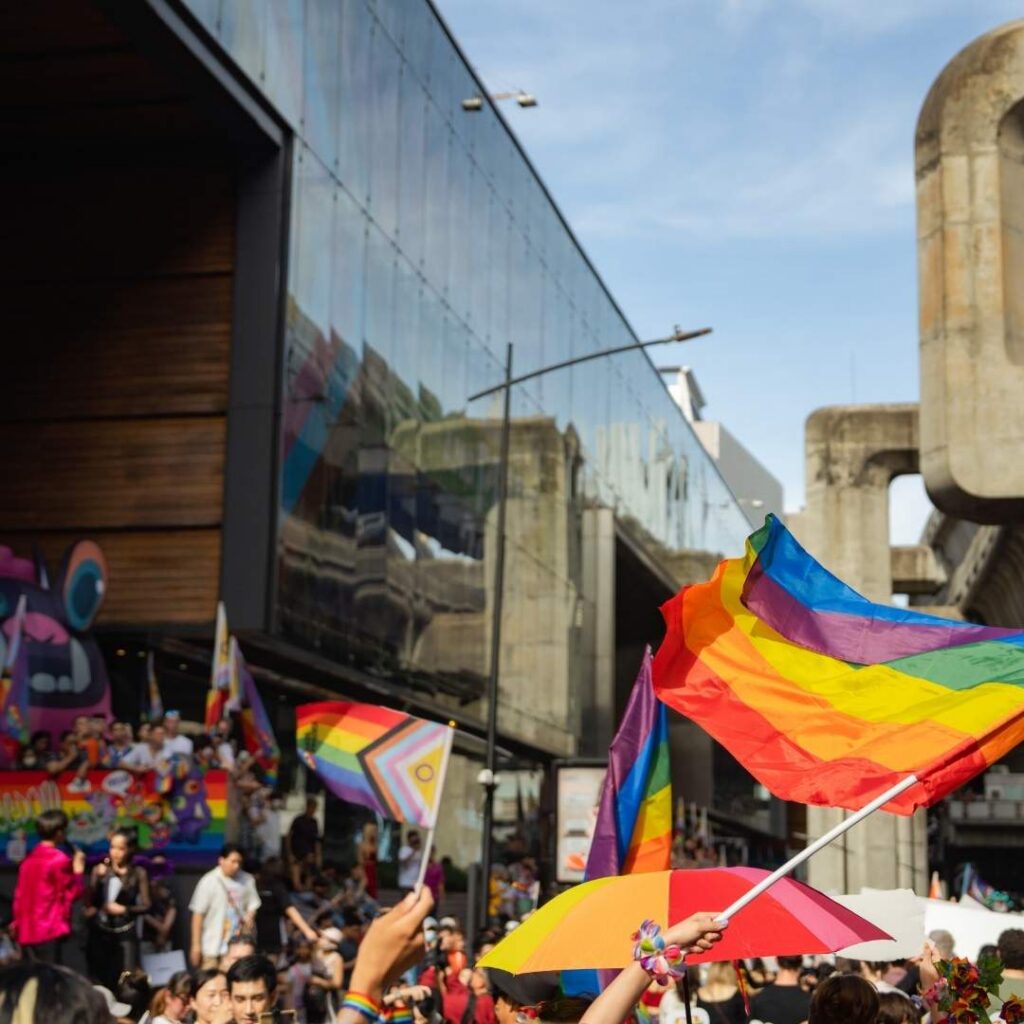 Menschen mit Pride-Flaggen bei einer LGBTQIA+ Demonstration als Symbol für Vielfalt, Sichtbarkeit und Inklusion.