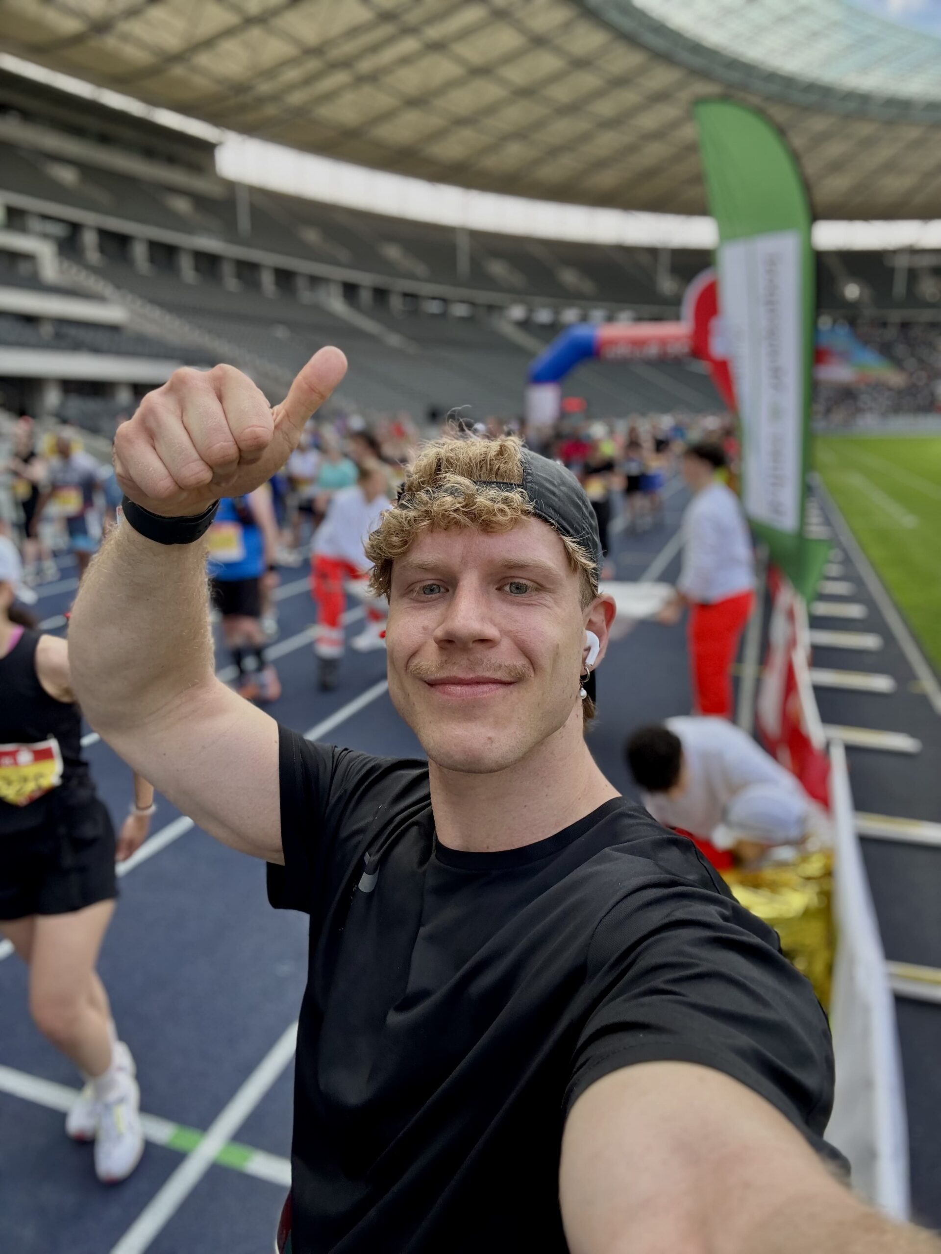 Consultant von Deloitte macht ein Selfie bei einem Laufevent und zeigt mit einem Daumen nach oben in die Kamera.