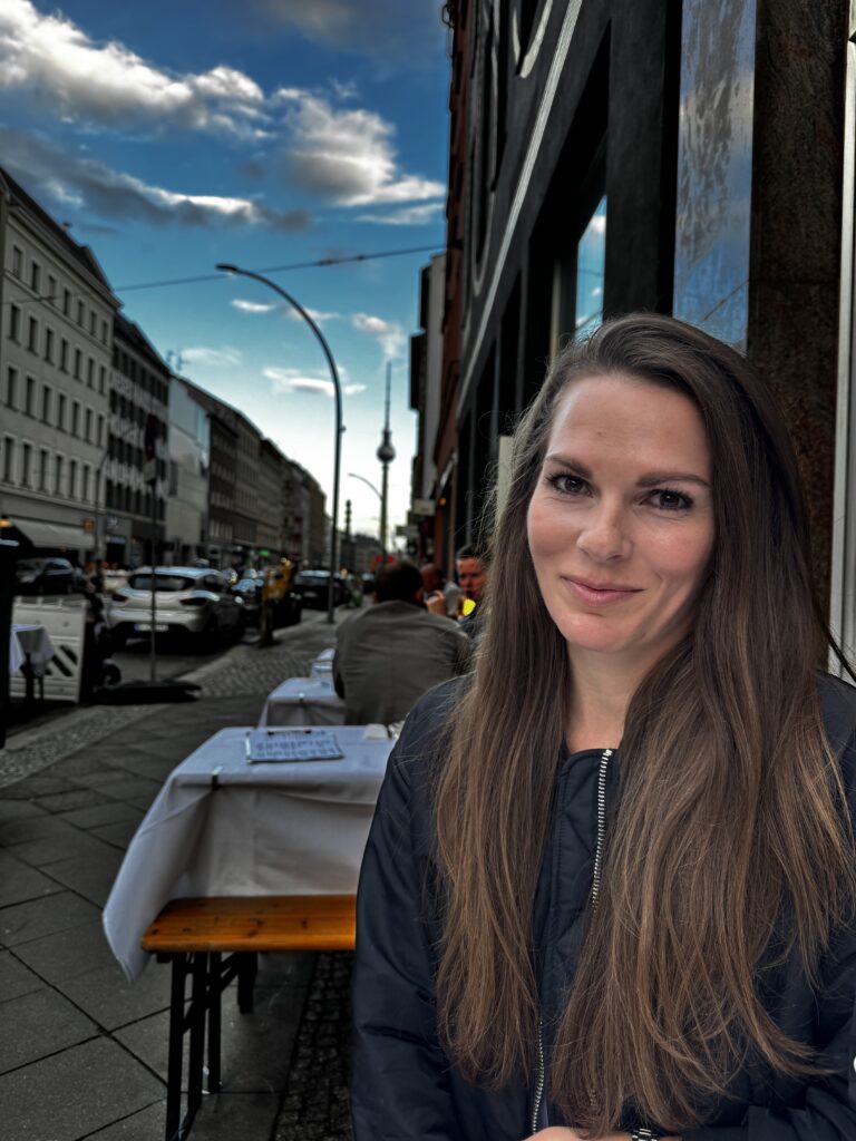 Leonie Westerburg, Senior Managerin bei Consistency, vor einer Berliner Straßenszene mit Fernsehturm im Hintergrund