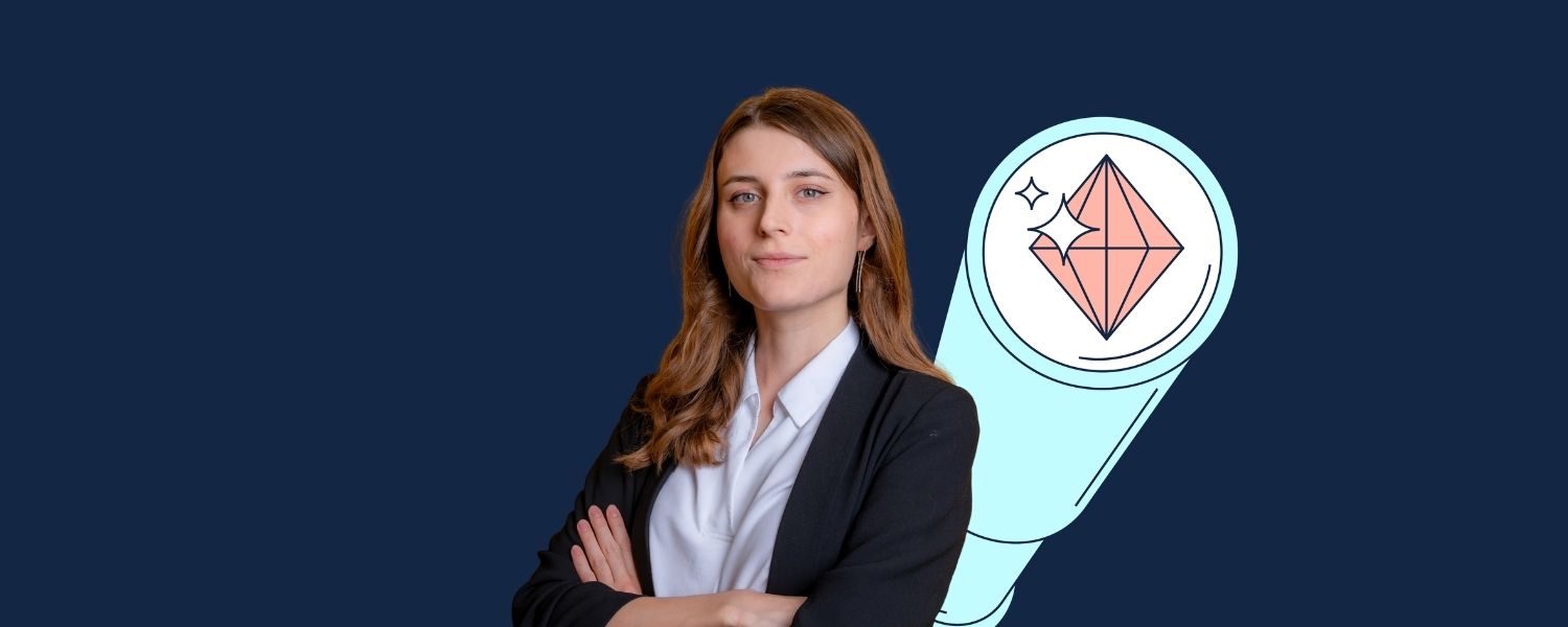 Vera trägt einen dunklen Blazer über einer hellen Bluse und steht mit verschränkten Armen vor dunkelblauem Hintergrund; daneben ist eine stilisierte Lupe mit geometrischem Symbol zu sehen.